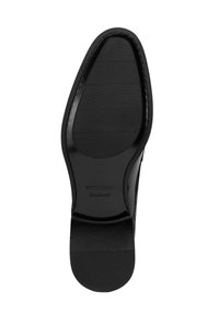 Suela de zapato de cuero negro con un patrón texturizado y una impresión de logo. El diseño es plano con una punta redondeada y un acabado suave.