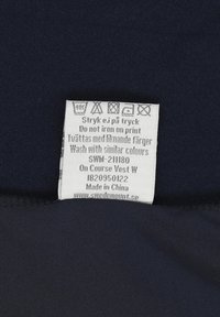 Kledinglabel met wasvoorschriften en instructies in het Zweeds en Engels, met het advies niet op de print te strijken en met soortgelijke kleuren te wassen.