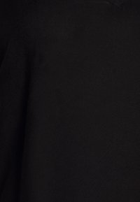 Černá látka s hladkým povrchem, s výstřihem do V a jednoduchou konstrukcí bez dalších vzorů nebo ozdob.