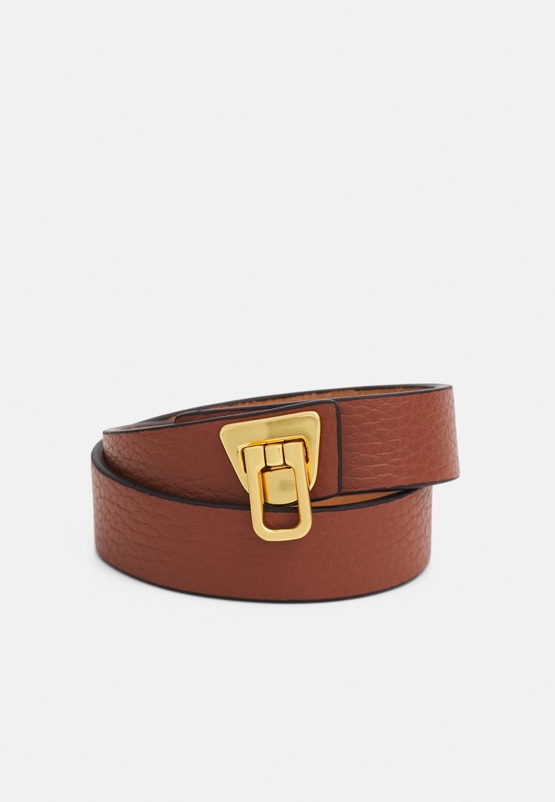 Ceinture en cuir brun texturé enroulée avec une boucle triangulaire dorée présentant une fermeture rectangulaire sur un fond blanc uni.