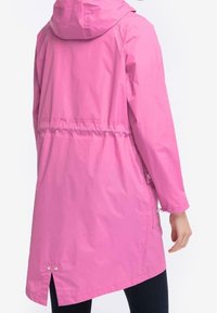 Vaaleanpunainen vedenpitävä takki hupulla, kapeutetulla vyötäröllä ja sivutaskuilla. Ominaisuuksina tyylikäs, sileä pinta ja takana tuuletusaukko.