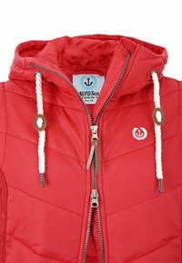 Red quilted jacket with a hood, featuring white rope drawstrings, a zip front, and a logo patch on the chest. Zipper pulls are metal.