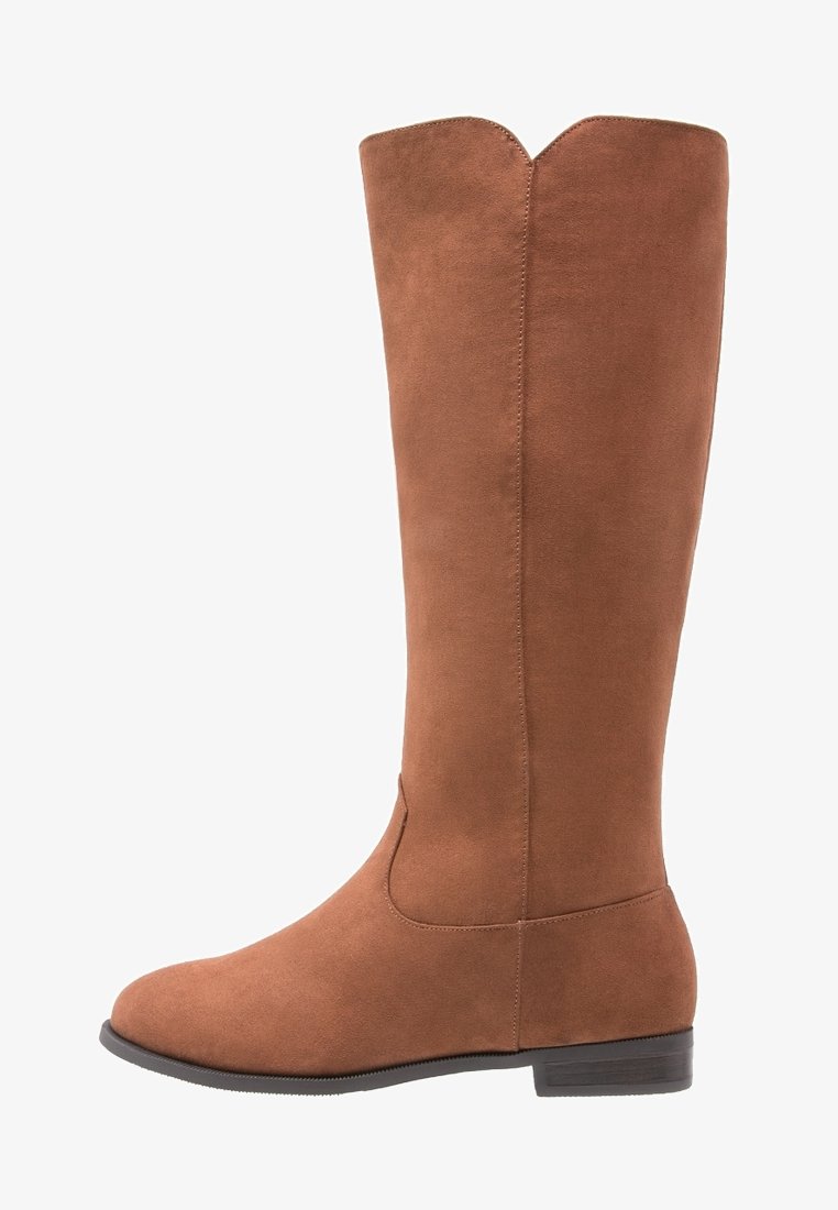 Bottes hautes jusqu'au genou en daim marron avec une texture lisse, un bout arrondi et un talon léger. Présentent une découpe en forme de V en haut pour le design.
