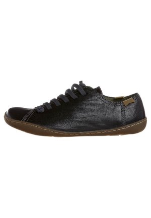Sort lavt skind sneaker med brun sål og mørke snørebånd, med minimal syning og en lille tan hæltab.