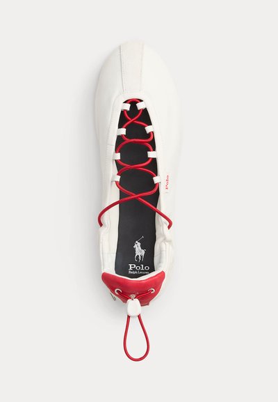 Witte leren ballerinaschoen met rode elastische gekruiste veters, rood hielstuk en zwarte binnenzool met Polo Ralph Lauren-logo.