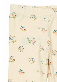 Leggings floreali con una base di crema chiara. Decorati con piccoli gruppi di fiori rossi, blu, gialli e rosa su un tessuto morbido ed elasticizzato.