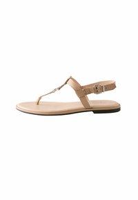Beige flat sandal with a toe post and adjustable ankle strap. Made of smooth synthetic material; features metallic accent detailing.