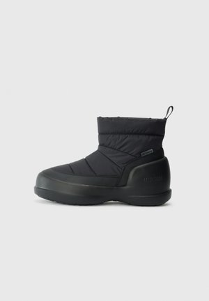 Schwarzer isolierter Knöchelstiefel mit gepolstertem Schaft, nahtlosem Design, Gummisohle und Zuglasche auf der Rückseite. Verfügt über eine flache und abgerundete Zehenpartie.
