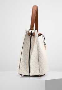 Weiße Handtasche mit strukturiertem Design, ausgestattet mit einem braunen Ledergriff und goldfarbenen Beschlägen, akzentuiert durch einen schwarzen Reißverschluss.