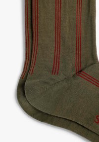 Calcetines verde oliva con rayas verticales rojas y verdes; tejido de punto texturizado; puntera y talón reforzados; pequeño logotipo de la marca en el lateral.