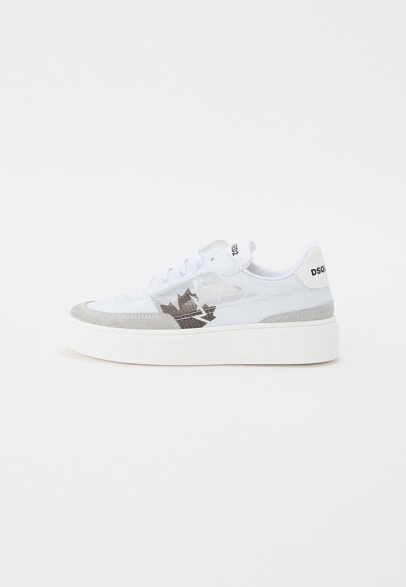 White sneaker with gray accents, suede and mesh materials, round toe, thick white sole, and a prominent logo feature on the side.