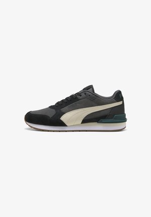 Sneaker Puma low-top in nero e grigio con striscia laterale bianca, lacci neri e suola bianca con battistrada marrone.