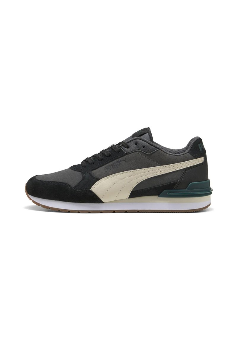 Niedrig geschnittenen Puma Sneaker in Schwarz und Grau mit einem weißen Seitenstreifen, schwarzen Schnürsenkeln und einer weißen Sohle mit braunem Profil.