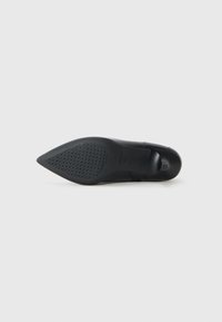 Sandal con tacco alto nero caratterizzata da una punta affusolata, tomaia in pelle liscia e suola in gomma testurizzata con un motivo geometrico per garantire aderenza.