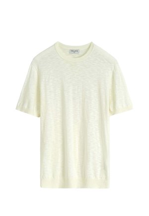 T-shirt tricoté à manches courtes, de couleur crème, avec encolure ronde et poignets côtelés, présenté sur un fond blanc uni.