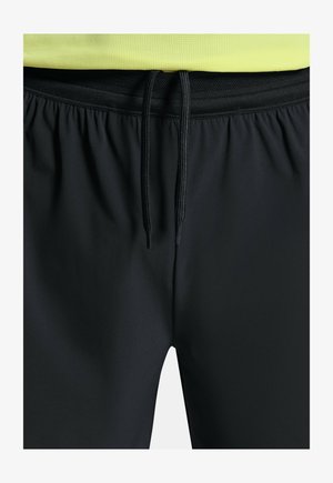 Černé sportovní šortky s elastickým pasem a šňůrkou, s hladkou texturou a bočním síťovinovým panelem pro prodyšnost.