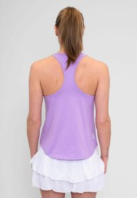 Lila ärmelloses Sportoberteil mit Racerback-Design, glatter Textur und abgerundetem Saum. Getragen mit einem weißen, schichtigen Rock.