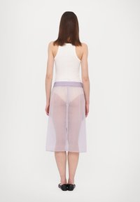 Haal lavenderi kleit, millel on elastne vöökoht, põlvekõrgune, taga lõhikuga, kantud valge triiksärgi ja mustade korterkingade peale.