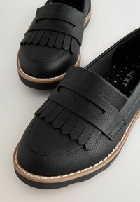 Sorte læder loafers med franje-design, rund tå, gummisål og dekorativ syning. Akcentueret med en struktureret overflade.