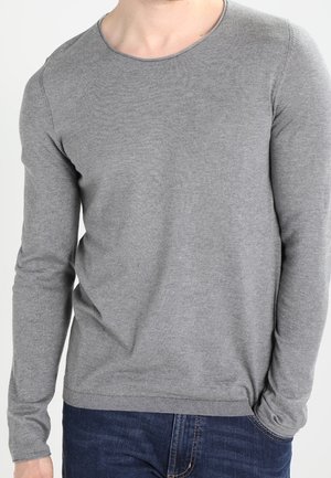 Pull gris à manches longues avec un col rond, fabriqué à partir d'un matériau doux ; présente des poignets et un ourlet côtelés, associé à un jean bleu.