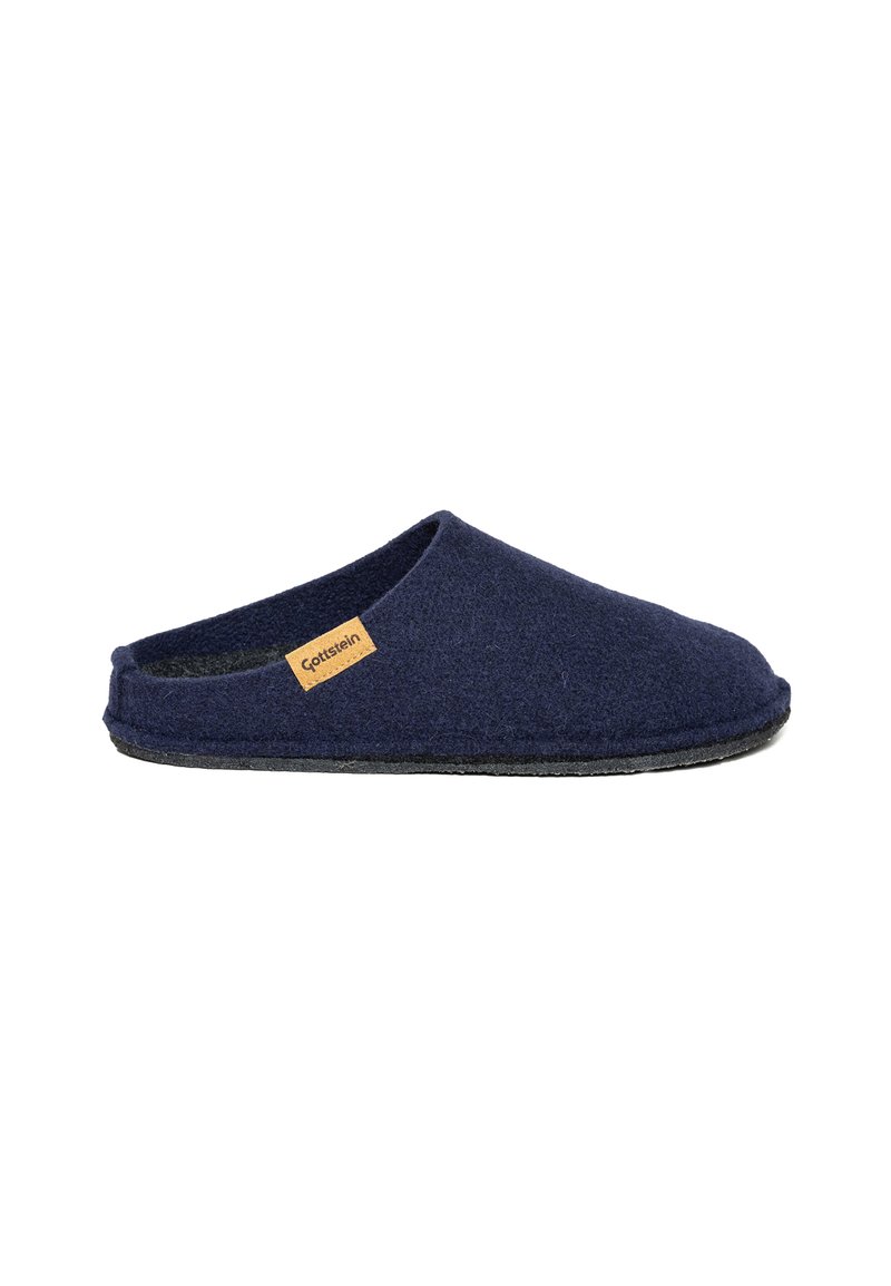 Pantofole in lana navy con retro aperto, texture morbida e suola piatta in gomma nera; presenta un piccolo etichetta beige sul lato.