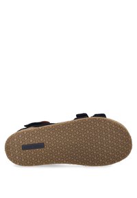 Schwarze Sandale mit zwei verstellbaren Riemen, ausgestattet mit einer strukturierten Gummisohle und einem hellbraunen Korkfußbett. Markenlogo auf der Sohle sichtbar.