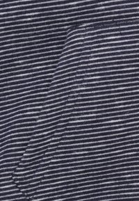 Marineblauwe stof met dunne witte strepen, met een zachte textuur. Het patroon is consistent en gelijkmatig verdeeld over het materiaal.