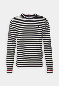 Pull à manches longues à rayures horizontales bleu marine et crème, col et poignets côtelés avec un accent rouge, tissu en mélange de coton.