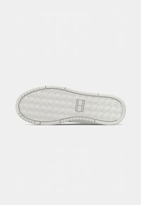 White rubber shoe sole featuring a textured, hexagonal pattern with ridges and a central logo inset. Flat design for traction.