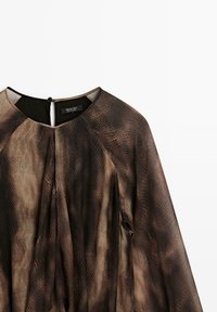 Haut marron léger avec un motif imprimé serpent, avec un col rond, des manches longues et un détail dos avec ouverture goutte d'eau.