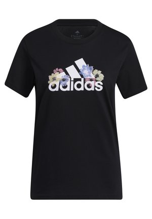 Person wearing black Adidas t-shirt with colorful floral logo and light gray sweatpants, shown from neck to hips.