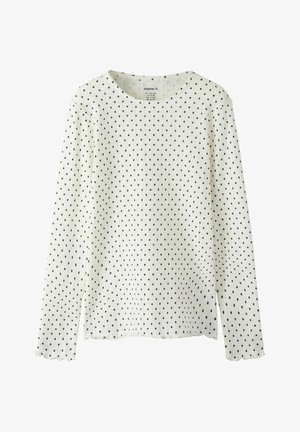 Top blanco de manga larga hecho de tela texturizada con lunares negros. Presenta un escote redondo y puños con borde festoneado. Diseño sencillo.