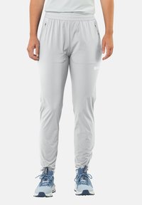 Lichtgrijze sportbroek met een elastische tailleband, ritszakken en een tapered design. Gemaakt van een gladde, lichte stof.