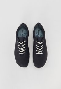 Fekete perforált sneaker fehér fűzőkkel, könnyű kialakítással és kék márkázott talppal. Kerek orr és rugalmas talp.