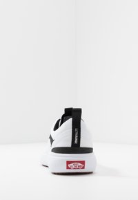 Weißer Sportschuh mit einer strukturierten Mesh-Oberfläche, schwarzen Akzenten, einer Zuglasche mit der Aufschrift "ULTRARANGE" und einem roten Logo auf der weißen Gummisohle.