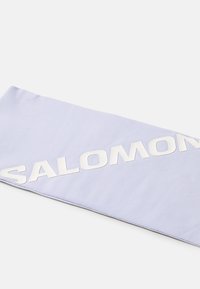 Lys lilla stofhovedbånd med et fremtrædende hvidt "SALOMON" logo. Fremstillet af glat materiale med et fladt design.