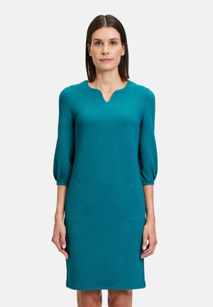 Türkisfarbene Kleid aus strukturiertem Stoff, mit V-Ausschnitt und dreiviertellangen Puffärmeln; ausgestattet mit zwei Seitentaschen. Klassische, taillierte Silhouette.