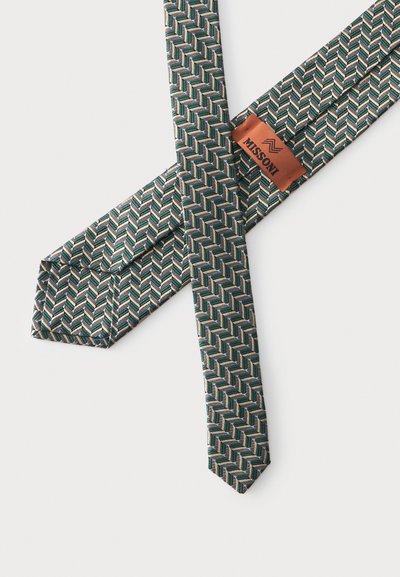 Cravate en soie avec motif géométrique chevron vert, bleu et beige, montrant une étiquette marron avec le nom de la marque Missoni.