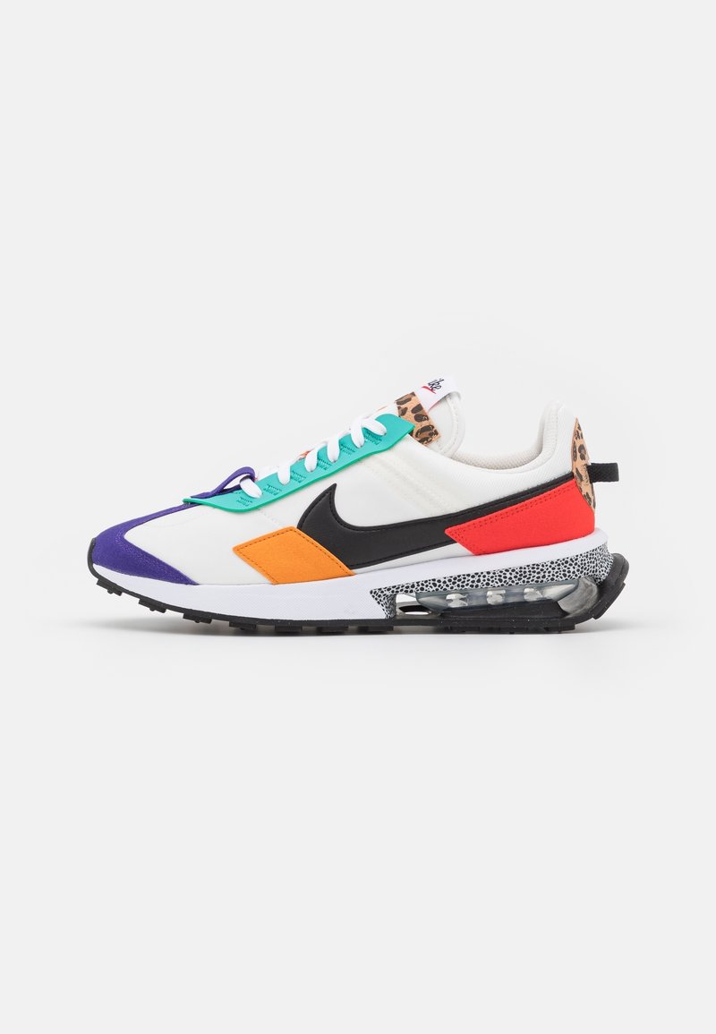 Baskets blanches avec le logo Nike noir, bout violet, accents orange et rouges, œillets turquoise, détails imprimé léopard et semelle visible avec coussin d'air.
