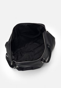 Black leather duffle bag with zip closure, wide opening, and textured interior. Features sturdy handles and smooth hardware accents.
