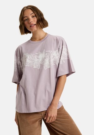 Lavender T-shirt met korte mouwen met wit bloemenontwerp en "Roxy" logo. Ontspannen pasvorm, katoenmateriaal, eenvoudige ronde hals en een gladde textuur.