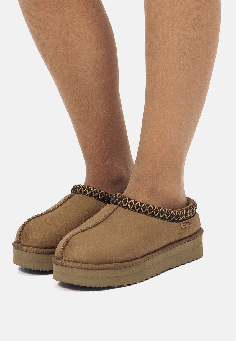 Scarpe slip-on marroni con un'esterno testurizzato, caratterizzate da un bordo intrecciato a motivo e una suola spessa e resistente.