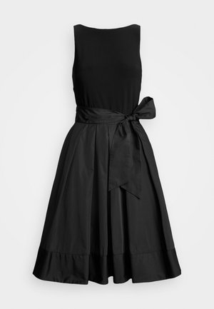 Robe midi noire sans manches avec corsage ajusté, jupe évasée et large ceinture nouée en nœud sur le côté droit.