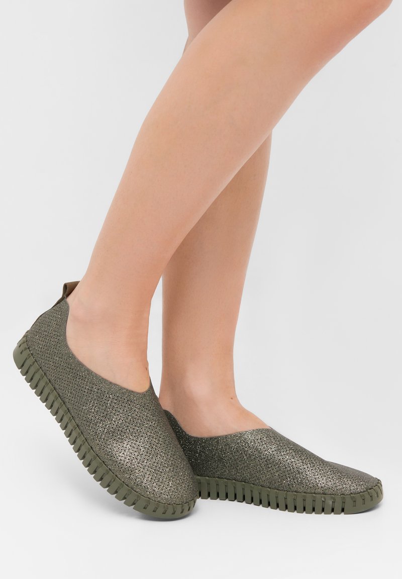 Green slip-on shoes with a textured, metallic-like upper and a rubber sole featuring ridges for traction. Rounded toe and back pull tab.