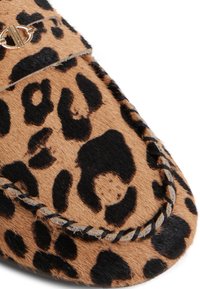 Mokkasiinilippu, jossa on leopardinprinttikuosi, pehmeä, teksturoitu vaalea ja musta turkis päällinen, kontrastoiva ompelu reunassa sekä kultainen varuste.