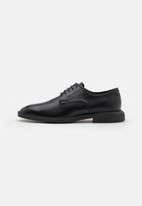 Svart lær dressko med en glatt finish, rund tå, snøring, og en lav gummisåle. Minimalistisk stil uten synlige mønstre.