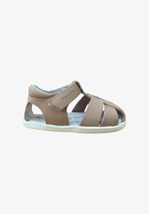 Sandalias de cuero marrón con tres tiras superiores y diseño abierto. Cuentan con cierre de velcro, suela de goma blanca y un interior acolchado para mayor comodidad.