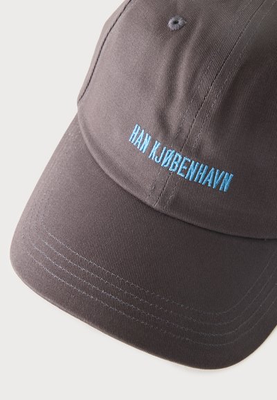 Casquette de baseball gris foncé avec texte brodé bleu clair "HAN KJØBENHAVN" sur le panneau avant.