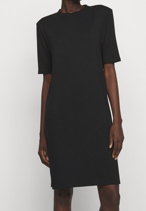 Robe noire à manches courtes avec une coupe décontractée, fabriquée dans un tissu doux et lisse. Elle présente un col rond et s'arrête juste au-dessus du genou.