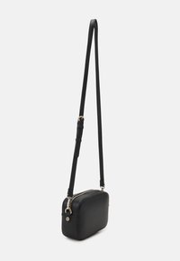 Bolso bandolera negro hecho de cuero texturizado, de forma rectangular, con cierre de cremallera y correa ajustable. Acentos en tonos dorados.